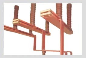 Red-sleeved busbars carried on ribbed post insulators, the flat contact pads at the top of each insulator left bare.
