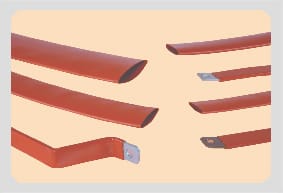 Cut lengths of red busbar sleeving: open tube ends, one length bent through a shallow offset, and three shrunk down onto flat bar ends with a bolt hole showing.