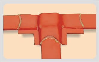Heat-shrinkable bus sheet shrunk over a busbar tee, the sheet conforming to all three legs with adhesive squeezed out along the seams.
